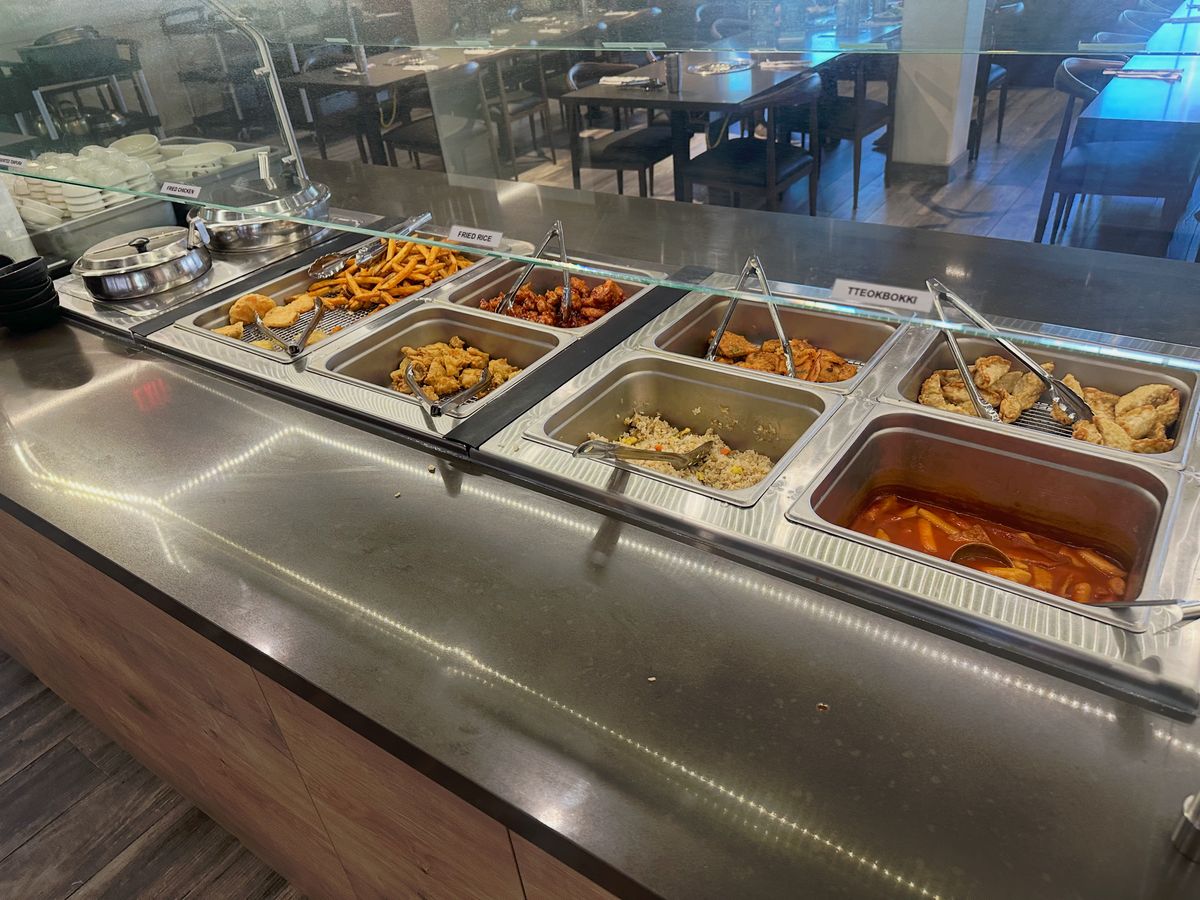 Self-serve counter with tteokbokki and fried sides